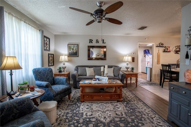 616 Third Ave, Lady Lake, FL 32159 - living room featuring light wood-style flooring, a ceiling fan, a textured ceiling, and visible vents