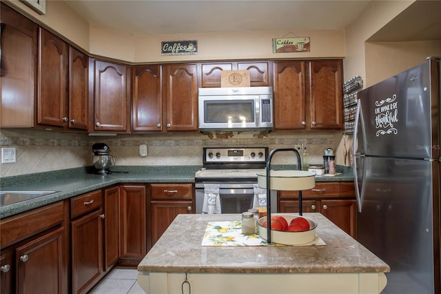 616 Third Ave, Lady Lake, FL 32159 - kitchen featuring light tile patterned floors, a center island, decorative backsplash, and stainless steel appliances