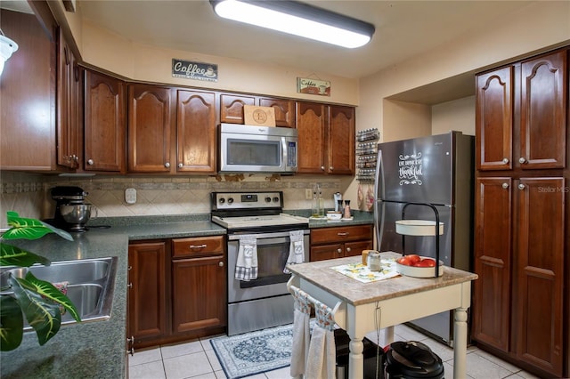 616 Third Ave, Lady Lake, FL 32159 - kitchen with appliances with stainless steel finishes, tasteful backsplash, dark countertops, a sink, and light tile patterned flooring
