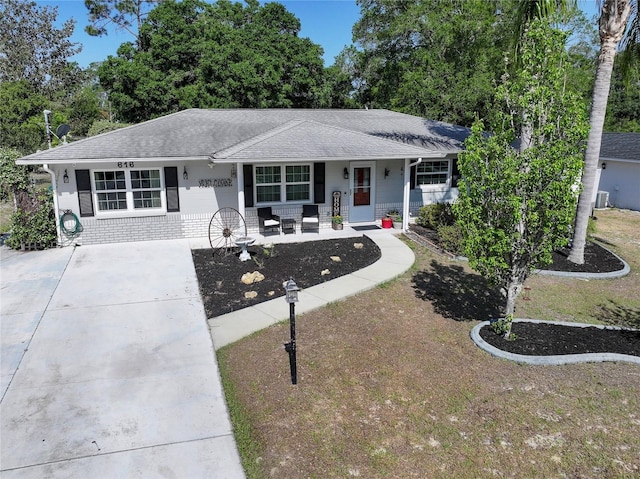 616 Third Ave, Lady Lake, FL 32159 - ranch-style house with a porch, roof with shingles, brick siding, and concrete driveway