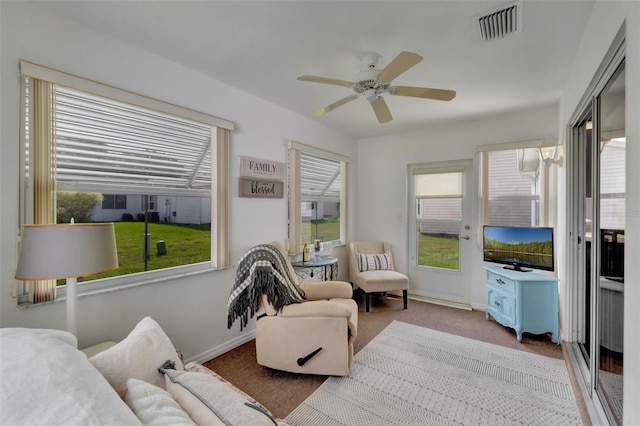 interior space with a ceiling fan, baseboards, and visible vents