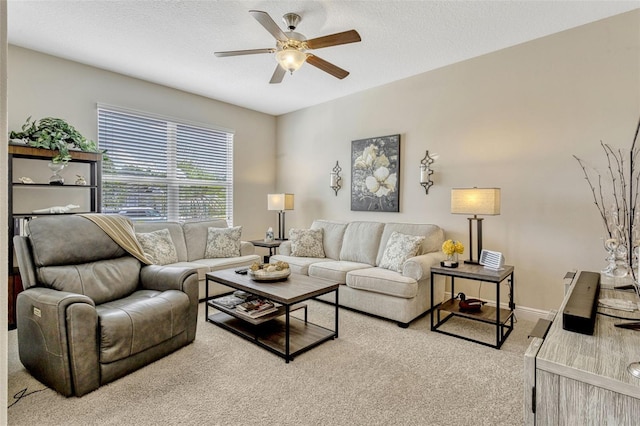 carpeted living room featuring a ceiling fan, baseboards, and a textured ceiling