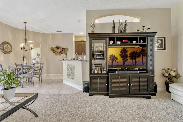 bar with light carpet, baseboards, light tile patterned floors, a notable chandelier, and hanging light fixtures