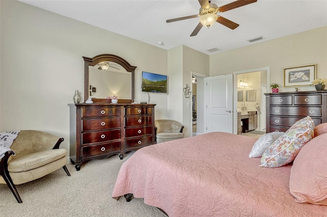 bedroom with carpet floors, ceiling fan, ensuite bath, and visible vents