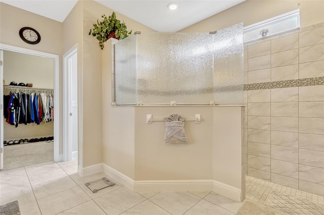 full bathroom with a walk in shower, tile patterned floors, a spacious closet, and baseboards