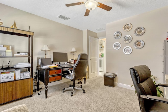 office area featuring carpet floors, visible vents, baseboards, a textured ceiling, and a ceiling fan