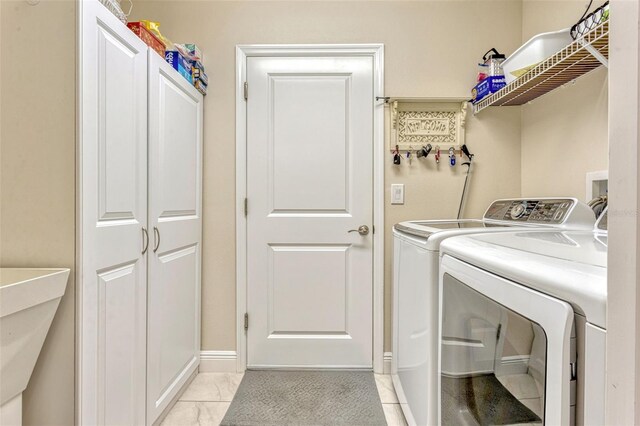 laundry room with laundry area, marble finish floor, washer and dryer, baseboards, and a sink