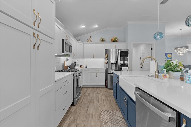 2129 Landrea Loop, The Villages, FL 32163 - kitchen with crown molding, white cabinetry, tasteful backsplash, appliances with stainless steel finishes, and blue cabinetry