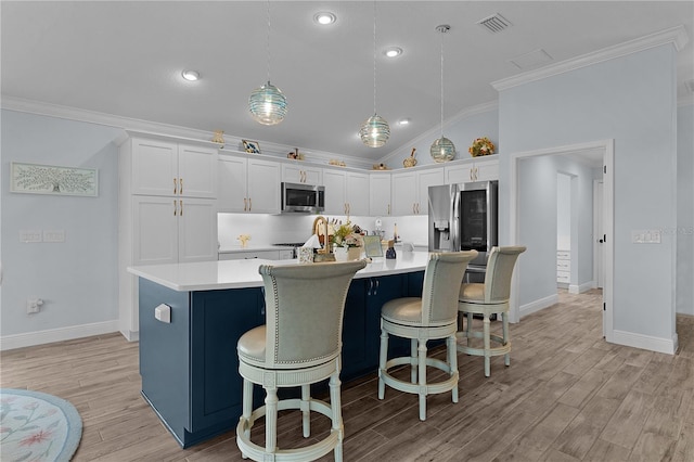 2129 Landrea Loop, The Villages, FL 32163 - kitchen featuring ornamental molding, white cabinetry, vaulted ceiling, and stainless steel appliances