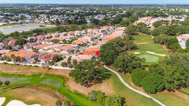 drone / aerial view featuring a residential view, view of golf course, and a water view