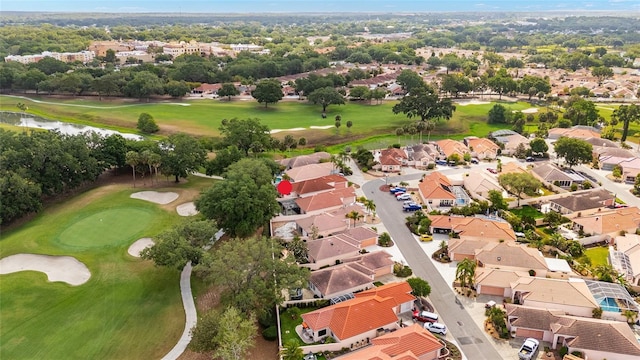 drone / aerial view with a water view, view of golf course, and a residential view