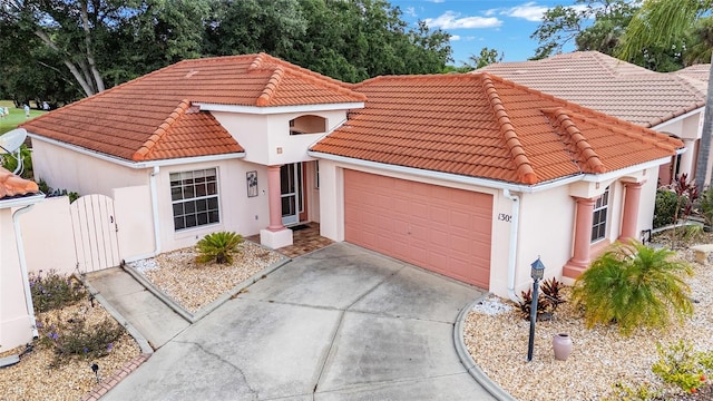view of front facade featuring stucco siding, a gate, an attached garage, driveway, and a tile roof