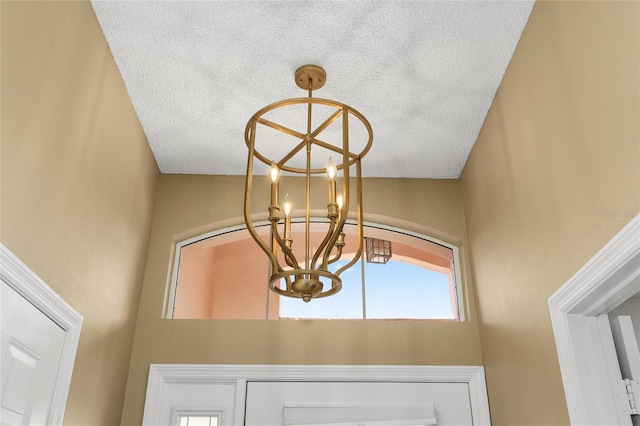 room details featuring a textured ceiling and a notable chandelier