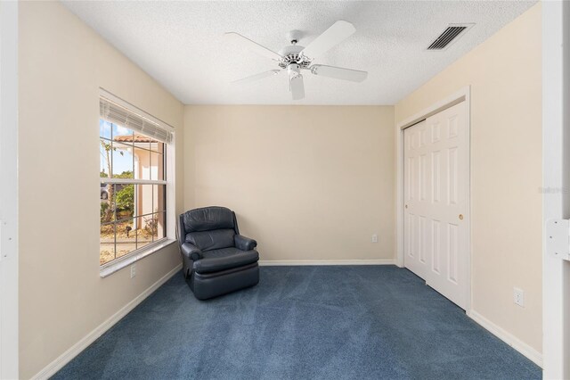 unfurnished room featuring ceiling fan, carpet, a textured ceiling, and visible vents