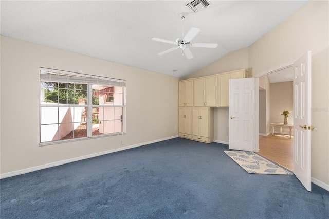 unfurnished bedroom featuring ceiling fan, visible vents, baseboards, dark colored carpet, and lofted ceiling