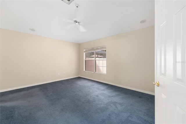 spare room with dark carpet, baseboards, and visible vents
