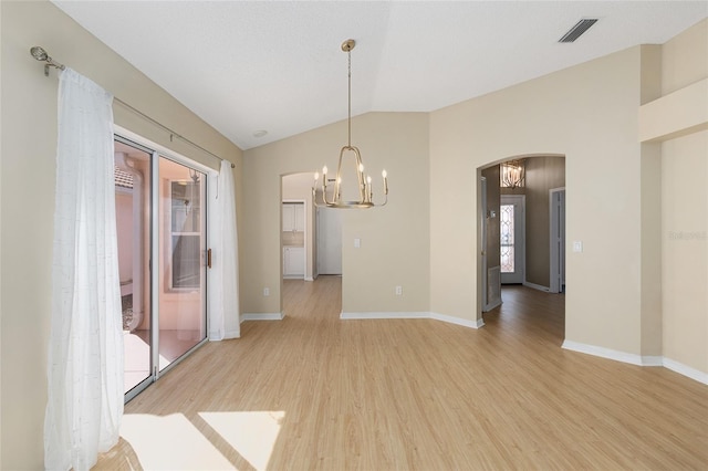 unfurnished dining area with light wood finished floors, arched walkways, a chandelier, lofted ceiling, and visible vents