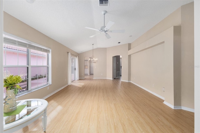 living area featuring visible vents, light wood-type flooring, baseboards, ceiling fan with notable chandelier, and lofted ceiling