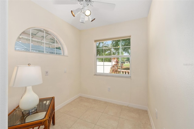 spare room featuring baseboards, ceiling fan, and light tile patterned floors