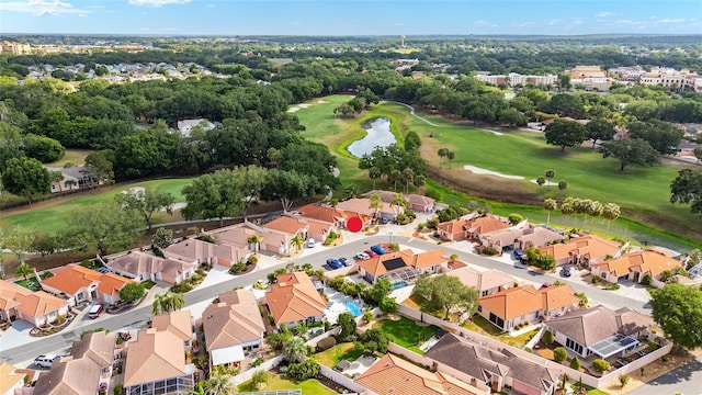 drone / aerial view with a water view, golf course view, and a residential view