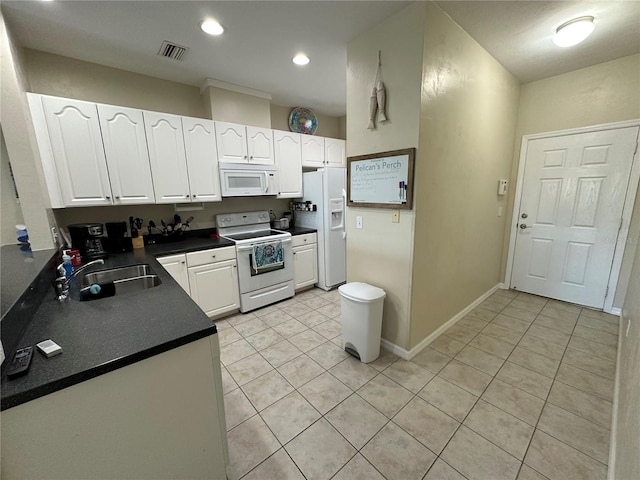 54 SE 910th Ave Unit 210/3, Suwannee, FL 32692 - kitchen with white appliances, white cabinets, dark countertops, a sink, and light tile patterned flooring