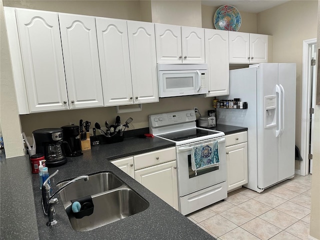 54 SE 910th Ave Unit 210/3, Suwannee, FL 32692 - kitchen with white appliances, a sink, white cabinetry, dark countertops, and light tile patterned floors
