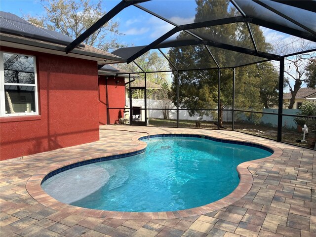 view of swimming pool with a patio, a fenced in pool, and a lanai