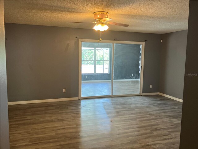 empty room featuring baseboards, a ceiling fan, a textured ceiling, and wood finished floors