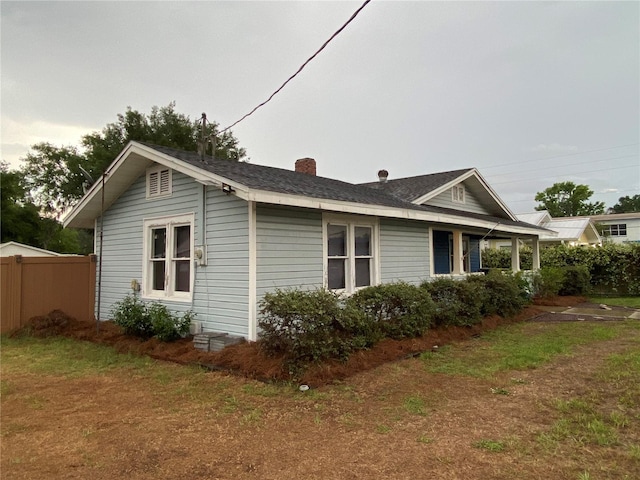 view of property exterior featuring fence and a chimney