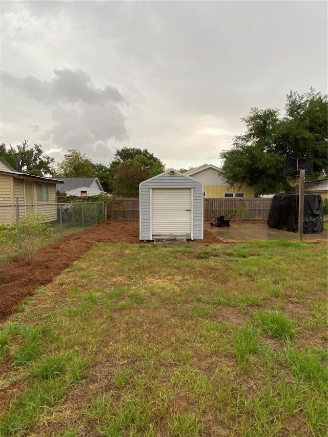 view of yard featuring a fenced backyard, an outbuilding, and a shed