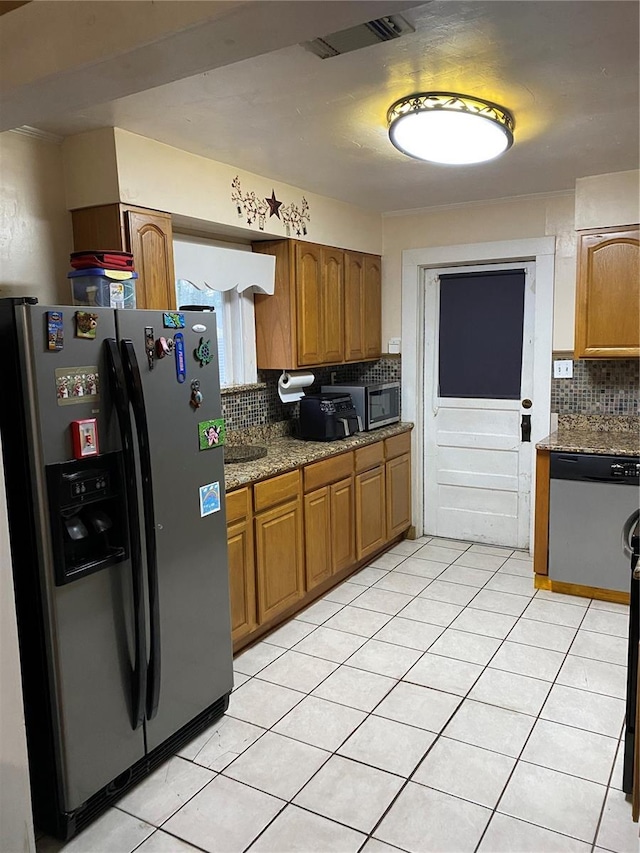 kitchen with decorative backsplash, brown cabinetry, visible vents, appliances with stainless steel finishes, and light tile patterned floors