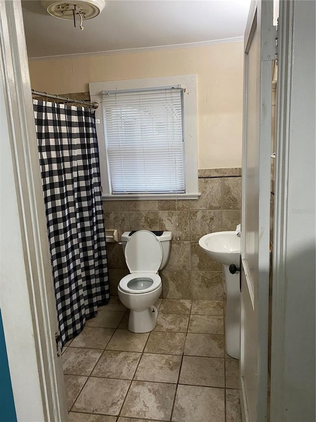 full bathroom featuring tile patterned flooring, toilet, tile walls, curtained shower, and ornamental molding