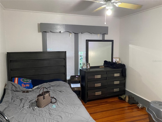 bedroom featuring ornamental molding, a ceiling fan, and wood finished floors