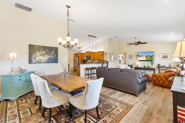 dining area featuring high vaulted ceiling, visible vents, ceiling fan with notable chandelier, and light wood-type flooring