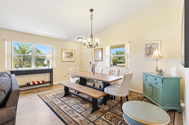 dining room featuring baseboards, a chandelier, plenty of natural light, and light wood-style floors