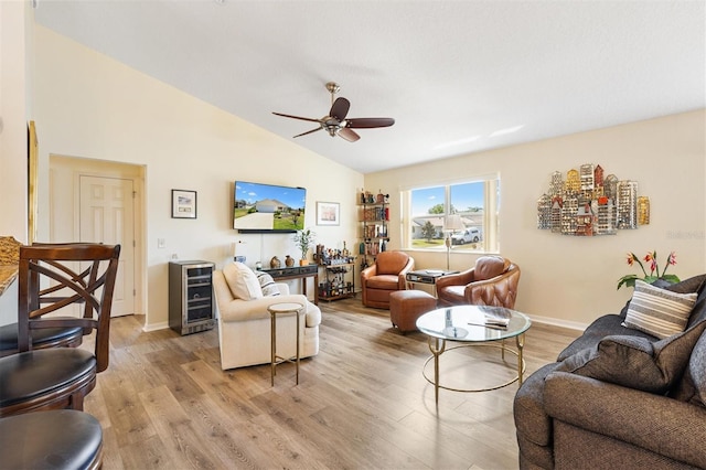 living room with beverage cooler, light wood-style floors, baseboards, ceiling fan, and high vaulted ceiling