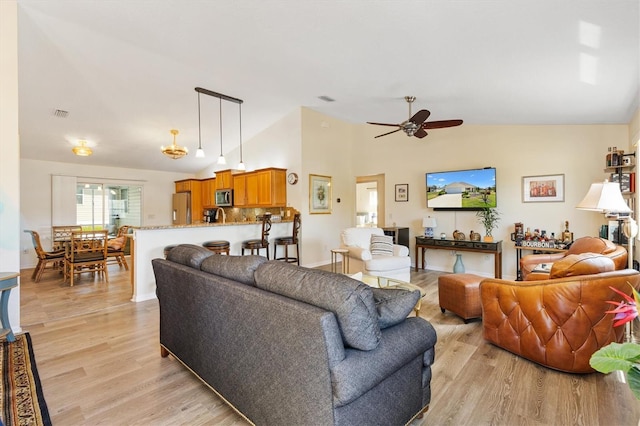 living room featuring ceiling fan, visible vents, high vaulted ceiling, and light wood-type flooring