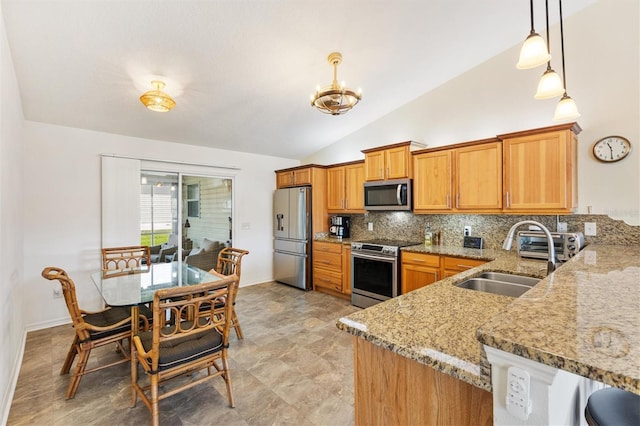 kitchen with light stone countertops, appliances with stainless steel finishes, a sink, decorative backsplash, and vaulted ceiling