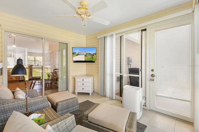 living area with a ceiling fan and light tile patterned floors