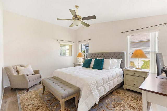 bedroom with light wood-type flooring, a ceiling fan, and baseboards