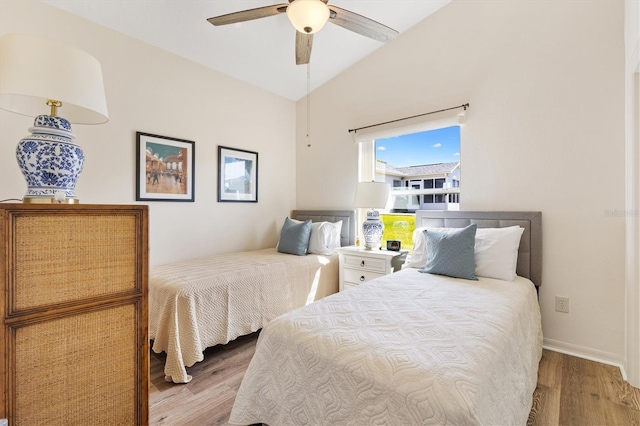 bedroom with baseboards, a ceiling fan, wood finished floors, and vaulted ceiling