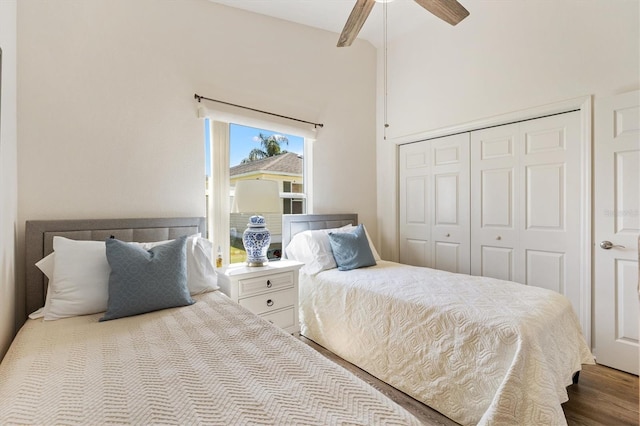 bedroom with ceiling fan, wood finished floors, lofted ceiling, and a closet