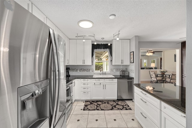 kitchen with a sink, appliances with stainless steel finishes, and white cabinets