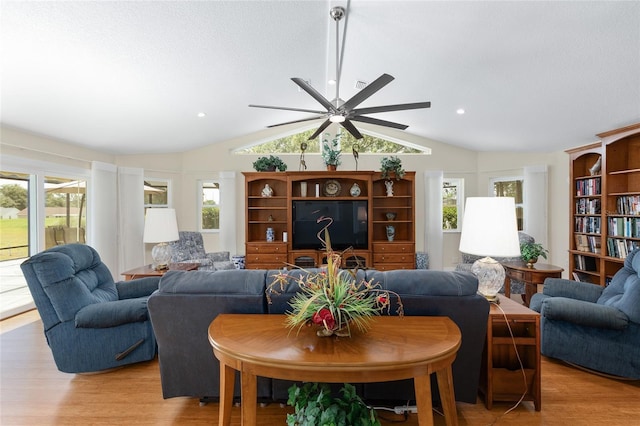 living room featuring ceiling fan, vaulted ceiling, a healthy amount of sunlight, and light wood-type flooring