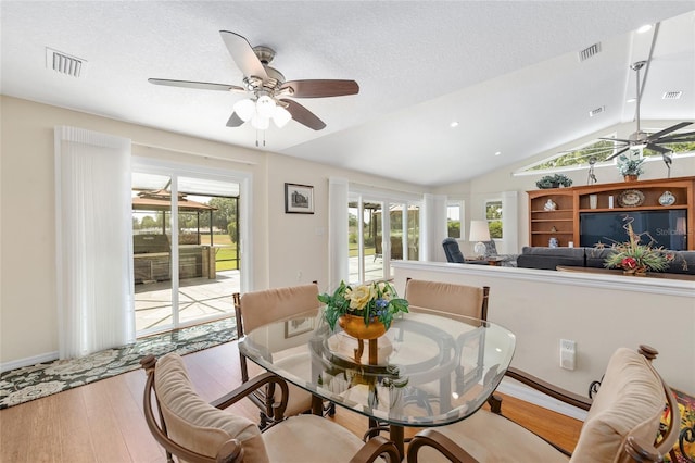 dining room with a ceiling fan, lofted ceiling, and wood finished floors