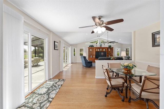 dining room with a ceiling fan, light wood-style flooring, and lofted ceiling