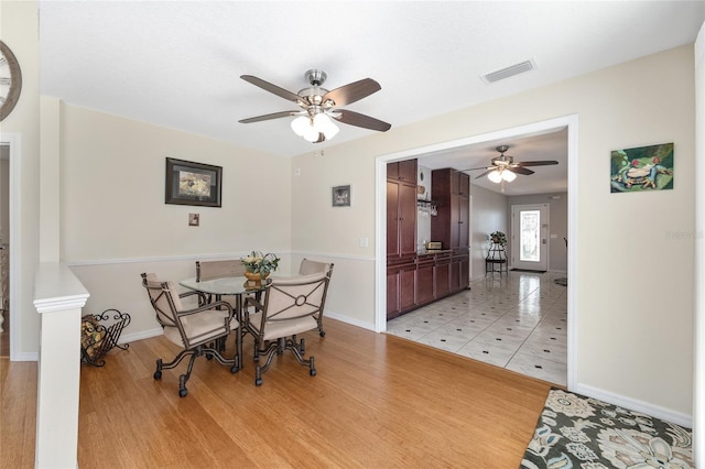 dining space featuring baseboards, ceiling fan, and visible vents