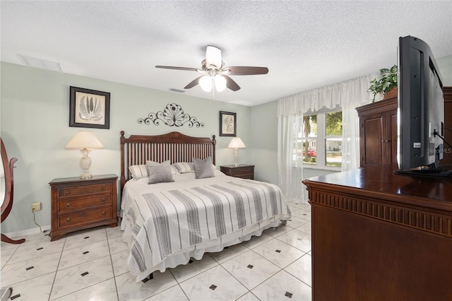 bedroom featuring baseboards, a ceiling fan, a textured ceiling, and visible vents