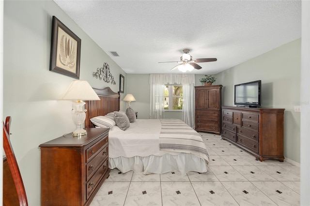 bedroom featuring visible vents, a textured ceiling, and ceiling fan