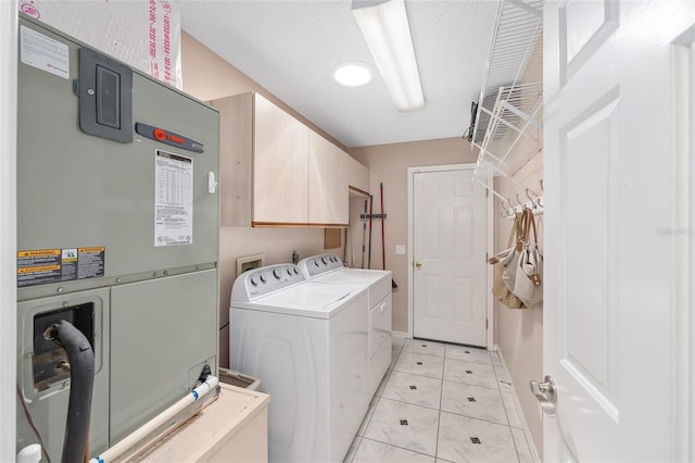 clothes washing area with cabinet space, light tile patterned floors, baseboards, heating unit, and washer and clothes dryer